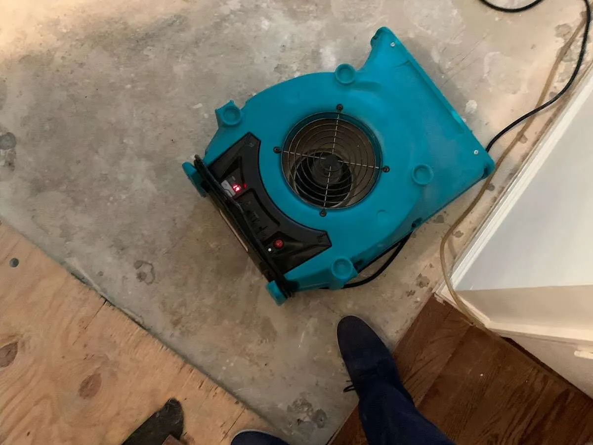 Air mover drying subfloor during Commercial Water Damage Restoration in Crowley